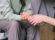 a woman holding another woman's hand in a supporting way