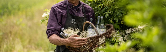 Man carrying luscombe drinks bottles in a basket Man carrying luscombe drinks bottles in a basket